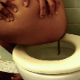 A black woman records herself shitting into a toilet in 3 different scenes. She does not show her face, but she does show us the finished product. About 10 minutes.